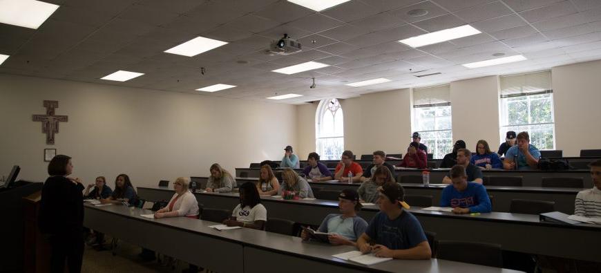 Students sitting in a classroom listening to their professor.